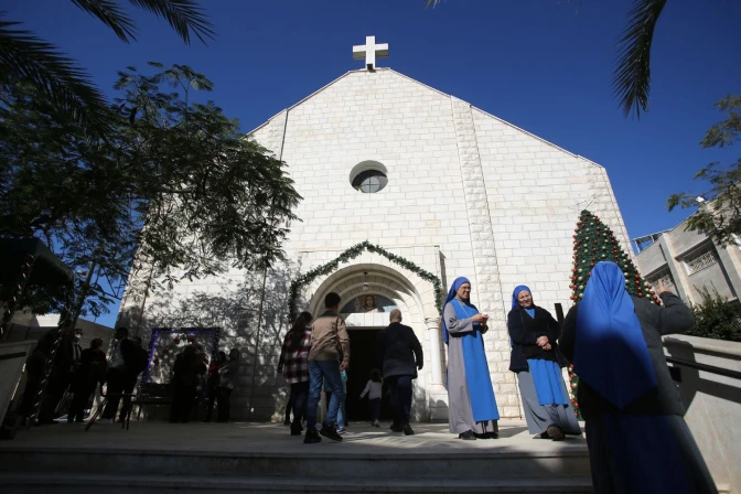 Los fieles cristianos palestinos se reúnen mientras asisten a una ceremonia dentro de la Iglesia de la Sagrada Familia, en la ciudad de Gaza, el 19 de diciembre de 2021.