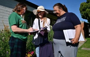 Las voluntarias Liz Grumbach (centro) y Patricia Jones se reúnen con Lucy Meyer (izquierda), quien firma una petición afuera de su casa en Phoenix el 13 de abril de 2024, mientras las voluntarias van puerta a puerta en busca de firmas para que la petición de la Ley de Acceso al Aborto de Arizona se incluya en la boleta electoral de noviembre de 2024 para que los votantes decidan. Crédito: FREDERIC J. BROWN/AFP vía Getty Images.