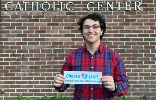 Gabriel Dionisi, un estudiante universitario de 22 años que crea pegatinas para coches en defensa de la vida con el objetivo de difundir el mensaje provida y concienciar a los demás, muestra una de sus obras. Crédito: Gabriel Dionisi