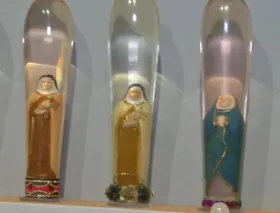 Denuncian una exposición con imágenes religiosas dentro de preservativos de cristal