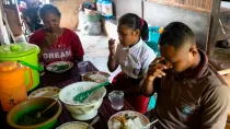 Una familia en Indonesia, beneficiaria de los programas de CRS, reza antes de la comida.