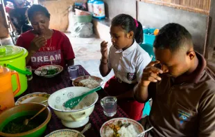 Una familia en Indonesia, beneficiaria de los programas de CRS, reza antes de la comida. Crédito: 	Pohl, Laura Elizabeth / CRS.