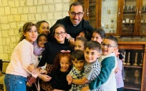 El P. Bashar Fawadleh, párroco latino de Taybeh, con niños de su comunidad.