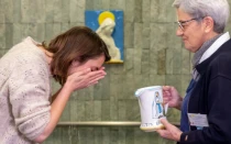 Una peregrina realiza el "gesto del agua" en las piscinas del Santuario de Lourdes.