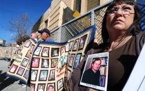 Esther Miller sostiene una fotografía y los documentos publicados sobre el padre Michael Nocita, mientras las víctimas y sus seguidores sostienen colchas con retratos de niños abusados, reunidos frente a la Catedral de Nuestra Señora de los Ángeles en Los Ángeles el 1 de febrero de 2013.