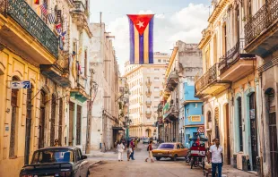 Una bandera cubana con agujeros ondea sobre una calle en en el centro de La Habana, Cuba. Crédito: Fotografía Julián Peters - Shutterstock