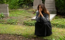 Imagen referencial de una mujer rezando en un cementerio.