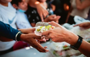Voluntarios otorgando alimentos a personas de escasos recursos. Crédito: Shutterstock