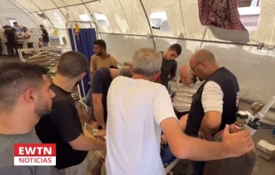 Un grupo de personas rodea a uno de los heridos que dejó el ataque a la parroquia católica de Gaza. Crédito: EWTN Noticias.