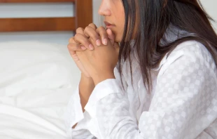 Imagen referencial de una mujer rezando. Crédito: Riskms / Canva