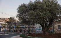 En Jerusalén, el 6 de octubre de 2025, la gente pasa junto a una valla publicitaria con los retratos de israelíes secuestrados en la Franja de Gaza desde 2023.