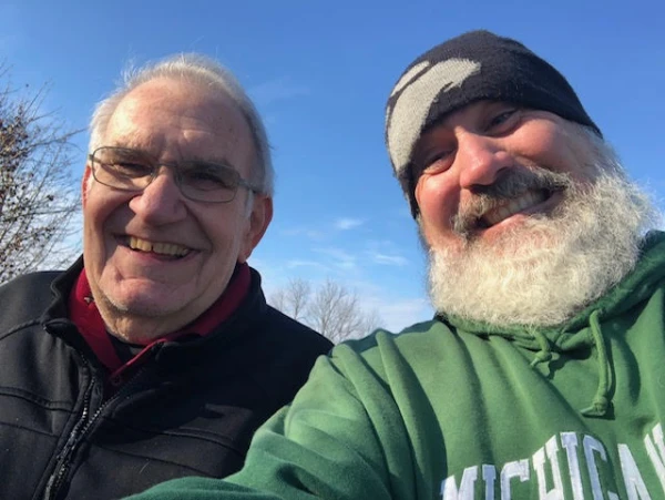 De izq. a der.: Gordon Krupp y el P. Joe Krupp posan sonrientes para una selfie. Crédito: Cortesía de Church of the Holy Spirit en Grand Blanc, Míchigan.