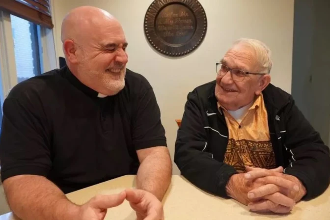 El P. Joe Krupp se ríe mientras su padre, Gordon Krupp, sonríe