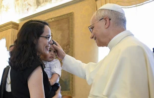 León XIV bendice a un niño en la Sala del Consistorio, durante una recepción. Crédito: Vatican Media.