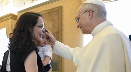 León XIV bendice a un niño en la Sala del Consistorio, durante una recepción.