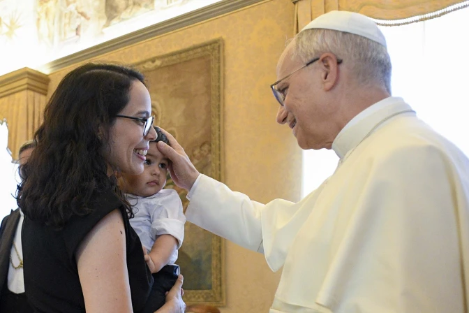 León XIV bendice a un niño en la Sala del Consistorio, durante una recepción.