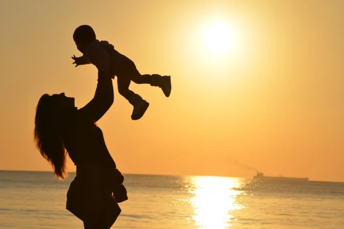 Una madre alza a su hijo. Maternidad.