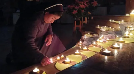Religiosa prendiendo una vela