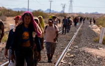Un grupo de migrantes caminan junto a las vías férreas para llegar a la frontera México-Estados Unidos.