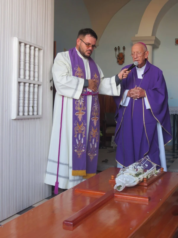 Mons. Emilio Aranguren ora ante el féretro de Mons. Peña. Crédito: Comunicaciones Obispado Holguín, Cuba.