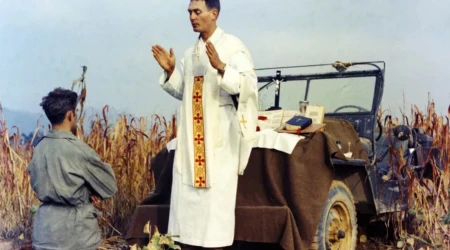P. Emil Kapaun celebra la Misa usando el cofre de un Jeep como altar