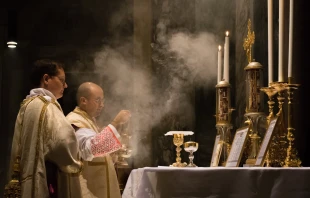 Un sacerdote católico celebra la Misa tradicional en latín con un diácono y subdiácono, incensando el altar en la Iglesia de San Pancracio, Roma. Crédito: Thoom / Shutterstock.