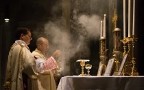 Un sacerdote católico celebra la Misa tradicional en latín con un diácono y subdiácono, incensando el altar en la Iglesia de San Pancracio, Roma.