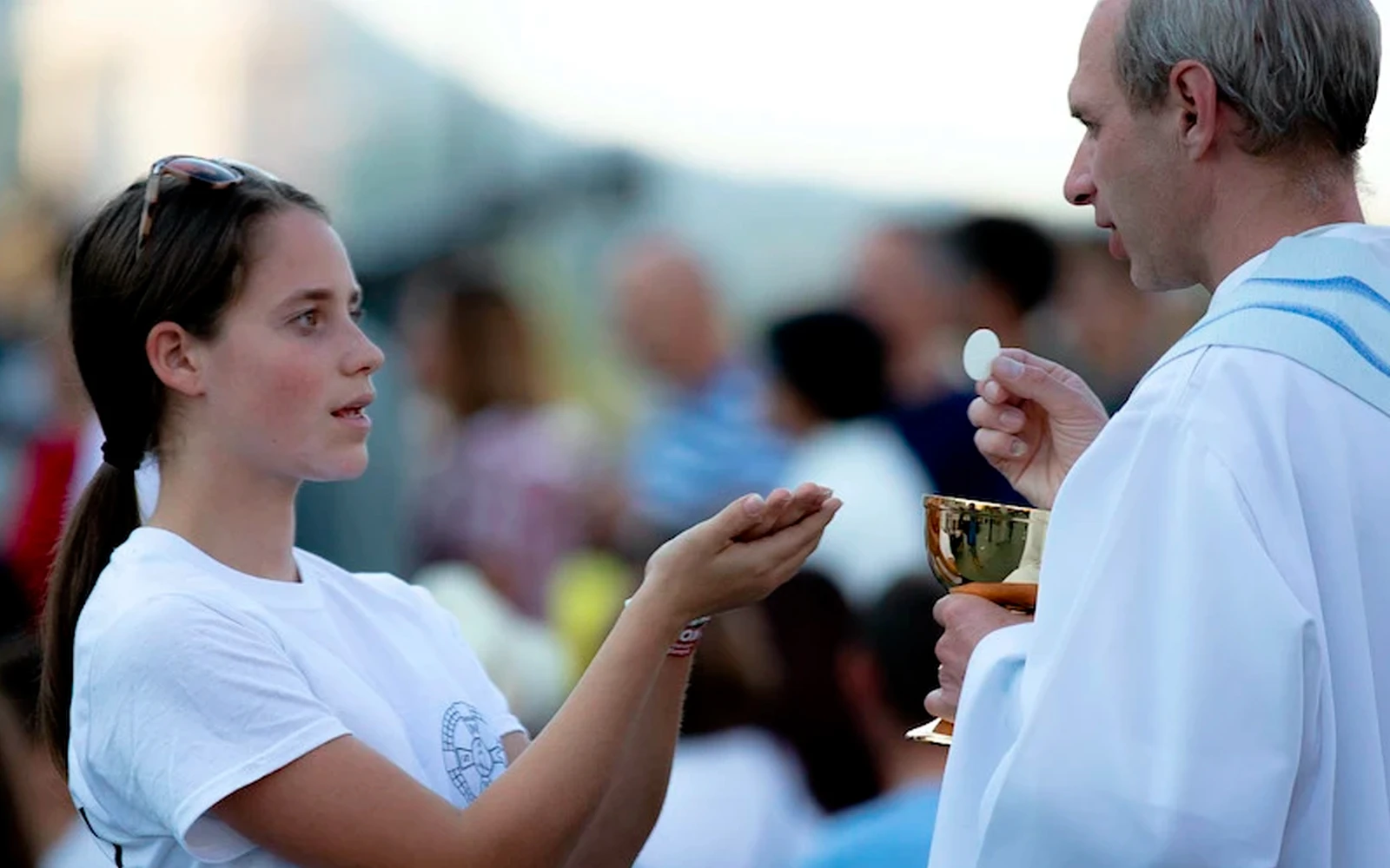 Una fiel recibe la Eucaristía de manos de un sacerdote.?w=200&h=150