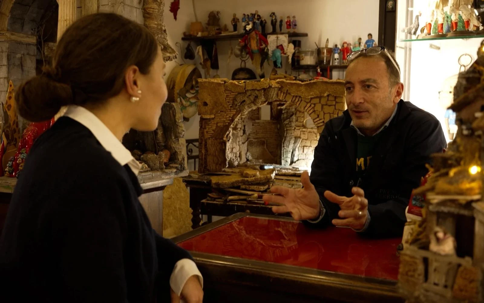 El artesano Giovanni Giudice habla con Valentina Di Donato, de EWTN News, sobre sus belenes napolitanos hechos a mano, una tradición que se remonta a más de 300 años, en la Bottega Ferrigno en Nápoles (Italia). Crédito: Gianpiero Passalia/EWTN News.