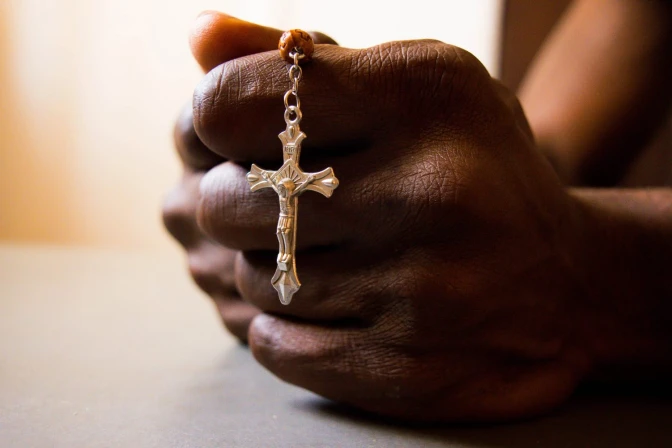 Manos sosteniendo rosario