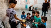 Niños cocinan fideos instantáneos en un horno improvisado con un barril reciclado en Rafah, en el sur de la Franja de Gaza, el 31 de octubre de 2023, en medio de los combates entre Israel y Hamás.
