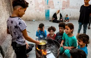 Niños cocinan fideos instantáneos en un horno improvisado con un barril reciclado en Rafah, en el sur de la Franja de Gaza, el 31 de octubre de 2023, en medio de los combates entre Israel y Hamás. Crédito: MOHAMMED ABED/AFP vía Getty Images