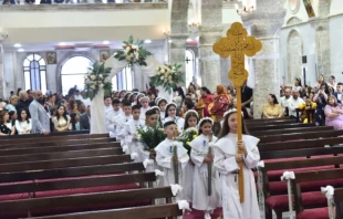 Niños entran en procesión a la iglesia de Santa María al-Tahir, también conocida como la Iglesia de la Inmaculada Concepción, en Bagdad, para su primera comunión. Crédito: Iglesia Católica Caldea