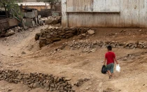 Un niño camina por un camino de tierra a través de uno de los barrios pobres de Lima.