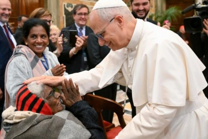 El Papa León XIV saluda a una mujer anciana.