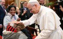 El Papa León XIV saluda a una mujer anciana.