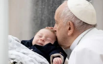 El Papa Francisco besa a un bebé durante su Audiencia General semanal del 10 de mayo de 2023.