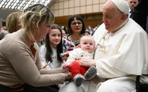 El Papa Francisco bendice a un bebé durante una audiencia general en el Vaticano.