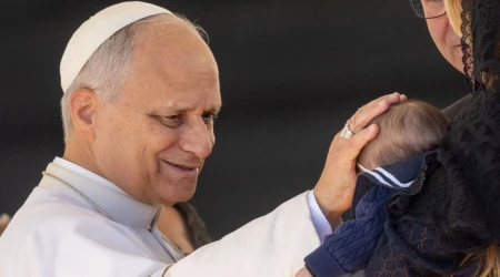 El Papa León XIV bendice un bebé en el Vaticano.