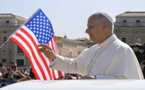 El Papa León XIV, nacido en Estados Unidos, saluda a los fieles durante su audiencia general del 6 de agosto de 2025, mientras la bandera de su país ondea en la Plaza de San Pedro. El 16 de agosto se cumplen los primeros 100 días de su pontificado.