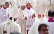 El Papa Francisco ora en presencia de algunos obispos.