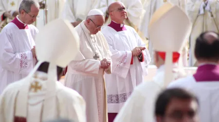 El Papa Francisco ora en presencia de algunos obispos.