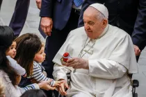 El Papa Francisco le entrega un obsequio a un niño al final de su audiencia general semanal en el Aula Pablo VI en el Vaticano, 3 de enero de 2024.