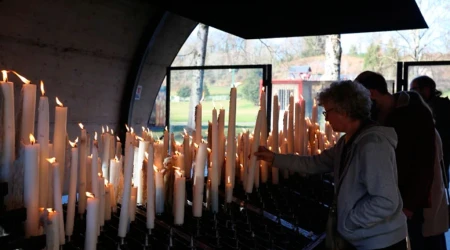 Peregrinos encienden velas en el Santuario de Lourdes en Francia.