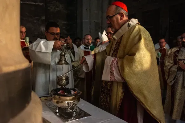 El Cardenal Pierbattista Pizzaballa coloca las brasas del fuego recién bendecido dentro del incensario. Crédito: Marinella Bandini