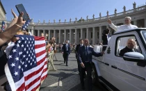 El Papa León XIV saluda mientras el papamóvil pasa junto a una multitud de peregrinos estadounidenses reunidos en la Plaza de San Pedro para la audiencia general del 18 de junio de 2025, en el Vaticano.