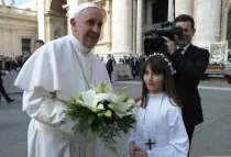 El Papa recibe unas flores para la Virgen de Luján de parte de una niña en la audiencia general (foto News.va)