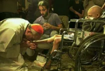 El entonces Cardenal Bergoglio, ahora Papa Francisco, lava los pies a un pequeño en silla de ruedas