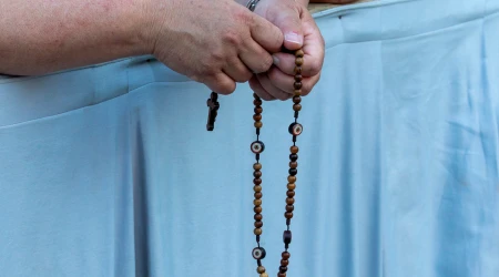 Persona rezando el rosario.