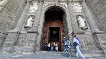 Fieles cruzan la "Puerta del Perdón" de la Catedral de Puebla (México).